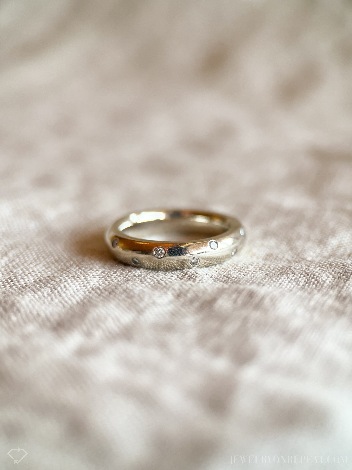 May include: A silver band ring with small diamonds set into the surface.